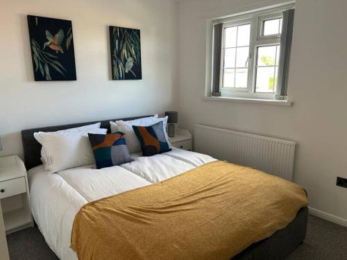 a bedroom with a bed with a yellow blanket on it at Atlantic House, Walking Distance to Cardiff Bay and City Centre with Parking in Cardiff