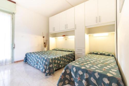 two beds in a small room withermottermottermottermott at Cozy and welcoming house with private garden in Lignano Sabbiadoro