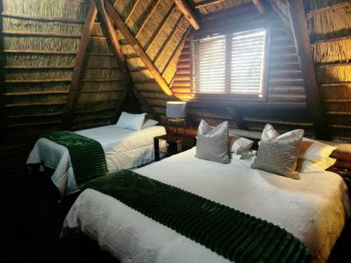 a bedroom with two beds and a window in a room at 4 Fish Eagle Lodge in Sasolburg