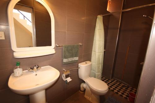 bagno con lavandino, servizi igienici e specchio di El Boussouni Hostel a Marrakech