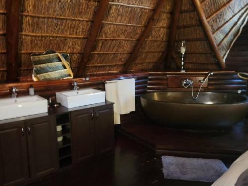 a bathroom with a large tub and two sinks at 4 Fish Eagle Lodge in Sasolburg