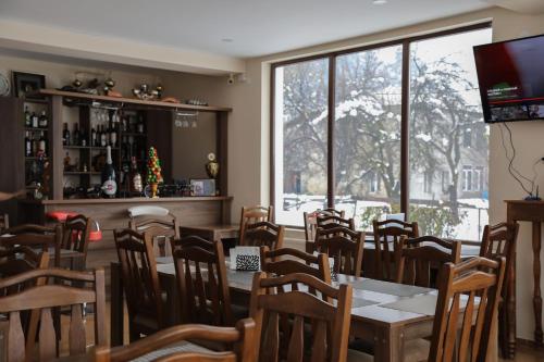 uma sala de jantar com uma mesa e cadeiras e uma janela em Hotel Ramaz Paliani em Mestia