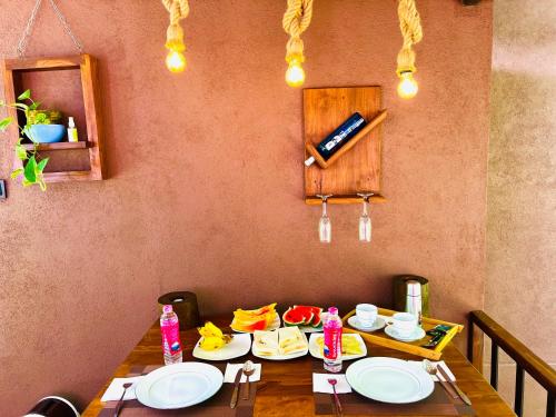 un tavolo in legno con piatti sopra di EdenHaven Cottage a Udawalawe