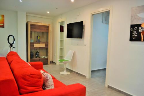 ein Kind auf einer roten Couch im Wohnzimmer in der Unterkunft Apartamentos Garage Centro in Málaga