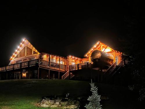 a large wooden house with lights on it at night at Mad River Cozy Cabin in Campton