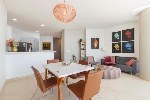 a living room with a table and chairs and a couch at Grand Marina Suites Santa Marta in Santa Marta