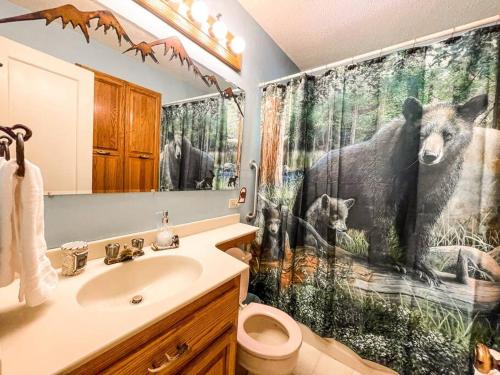 a bathroom with a bear shower curtain and a sink at Mountainside Cabin / peaceful / near hiking trails in Cascade-Chipita Park