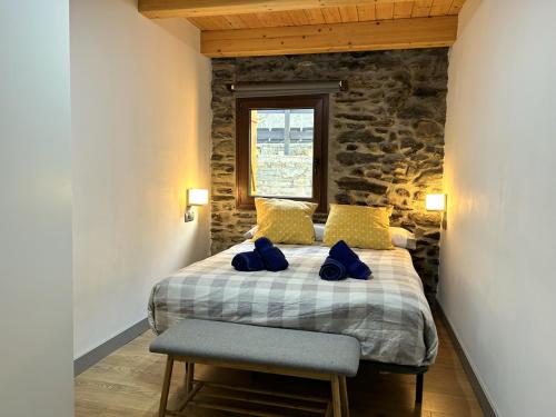 Un dormitorio con una cama con almohadas azules. en Casa de muntanya i familiar amb llar de foc by RURAL D'ÀNEU, en Escaló