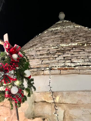 einen Weihnachtskranz auf einem Steingebäude in der Unterkunft Trulli bella vite in Putignano