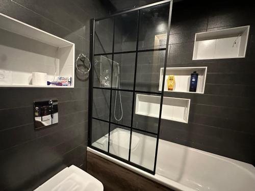 a bathroom with a glass shower with a toilet at Detached house a room in Essex in Waltham Abbey