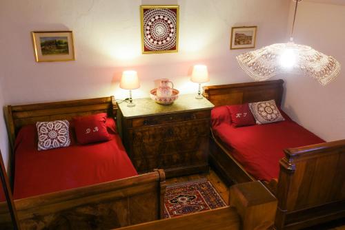 1 dormitorio con 2 camas con sábanas rojas en Gîte de la Bastide - Typique de Mirepoix, en Mirepoix