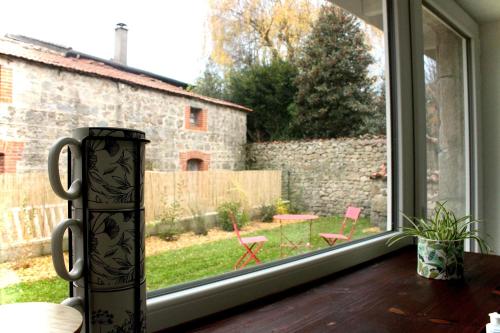 a window with a view of a yard at Superbe appartement avec jacuzzi et jardin privé in Marlhes