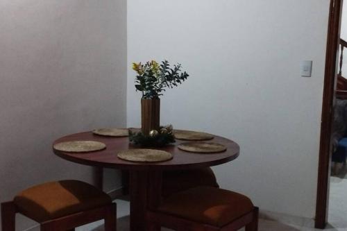 uma mesa com pratos e um vaso com flores em Hotel Mamma Mia em Duitama