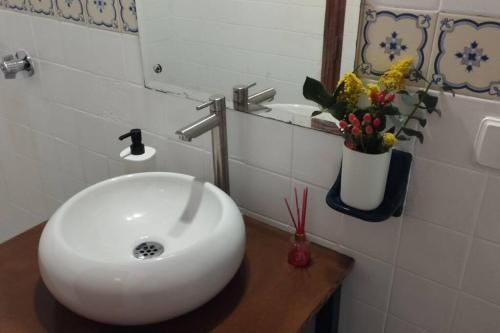 uma casa de banho com um lavatório branco e um vaso de flores em Hotel Mamma Mia em Duitama