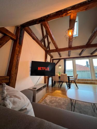 uma sala de estar com uma televisão e uma mesa em LudwigsHome: Zentralste Lage, SmartTV, Terrasse em Ludwigsburg
