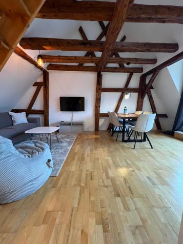 uma sala de estar com tectos em madeira e uma mesa em LudwigsHome: Zentralste Lage, SmartTV, Terrasse em Ludwigsburg