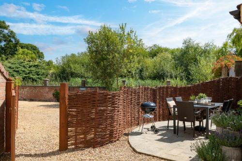 a barbecue in a garden with a brick fence at The Granary in Tunstead