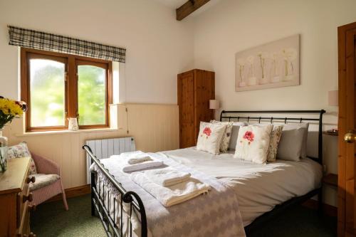 a bedroom with a bed with white sheets and a window at The Granary in Tunstead