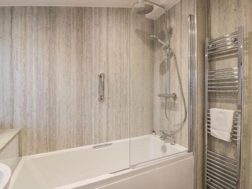 een badkamer met een wit bad en een douche bij Thorneydyke Cottage in Stirling