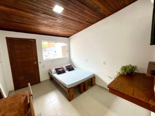 a room with a bed and a window and a door at Pousada Ilha do Campeche in Florianópolis