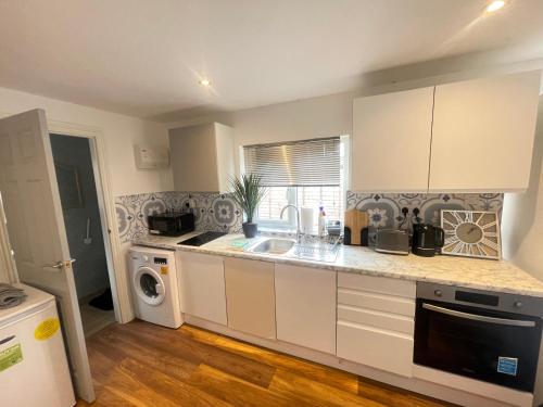 a kitchen with a sink and a dishwasher at One Bedroom Annex with Private Entrance in Morden