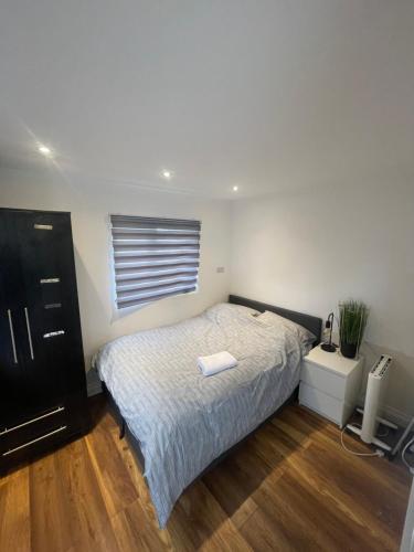um pequeno quarto com uma cama e uma janela em One Bedroom Annex with Private Entrance em Morden