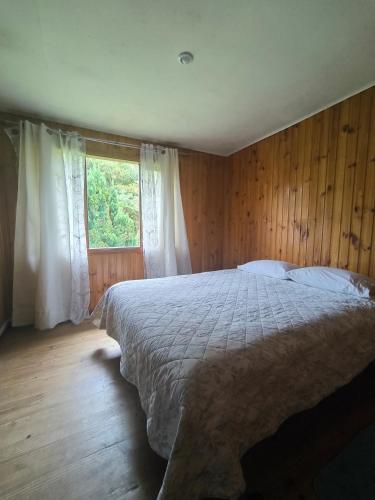 een slaapkamer met een groot bed en een raam bij Nómada Austral pieza 2 in Puerto Montt