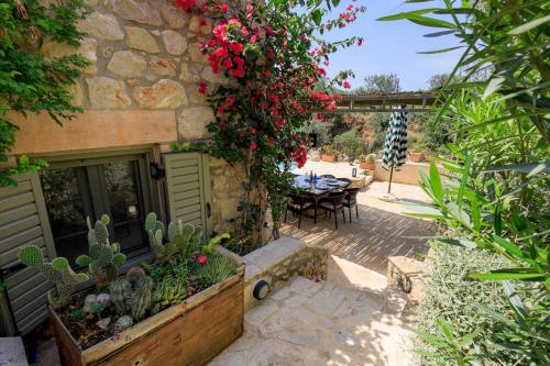 a patio with a table and a bunch of flowers at SPITI-MANOLIS in Levktron