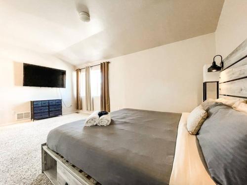 a bedroom with a large bed and a flat screen tv at The Mountain Lake Manor [Minutes from USAFA] in Monument