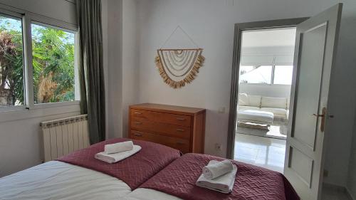 a bedroom with a bed with two towels on it at Opening Doors Premiá Dalt Amazing views w pool in Premia de Dalt