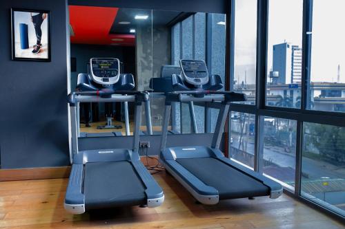 a gym with two treadmills in front of a window at Eden Place in Lagos