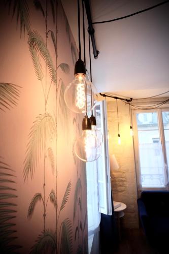 Cette chambre est dotée d'un mur orné d'une fresque murale représentant des palmiers. dans l'établissement La Bonbonnière, Bleue ou Rose, à Caen