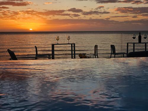 a swimming pool with a sunset over the ocean at Villa Dune Luxury Roof Top Pool Wellness in Gallipoli