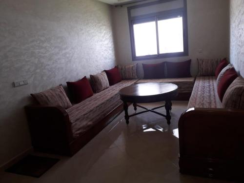 sala de estar con sofá y mesa en Résidence HAMZA en Douar Ourlali