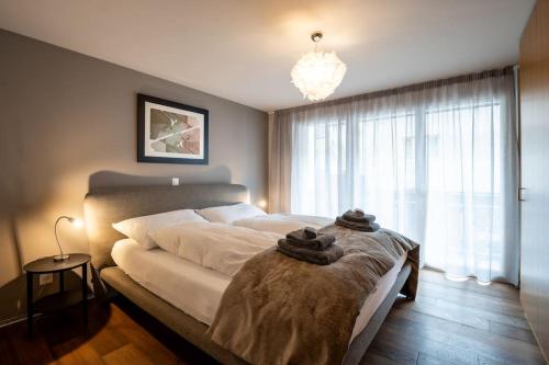 um quarto com uma cama grande e toalhas em Mera Peak Prime Apartment em Zermatt