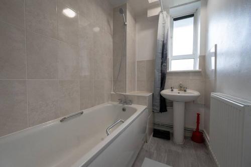 a white bathroom with a tub and a sink at Stunning apartment in Dulwich in London