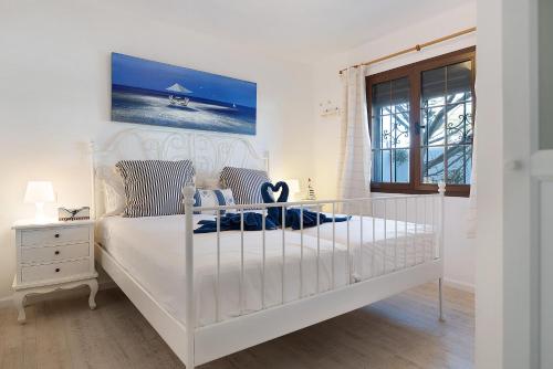 a white bedroom with a white bed and a window at Puerto Chico A in Playa Blanca