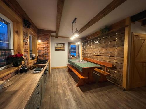 a bathroom with a sink and a wooden wall at Chata Borówkowe Wzgórze in AdamÃ³w