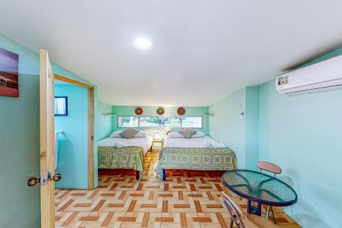 a bedroom with two beds and a table and a window at Nueva Villa Paraíso Four Villas in Lagunillas