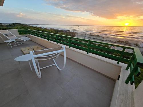 a balcony with a view of the beach at sunset at Villa Dune Luxury Roof Top Pool Wellness in Gallipoli