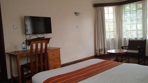 a bedroom with a bed and a flat screen tv at dreamplace Gigiri in Nairobi