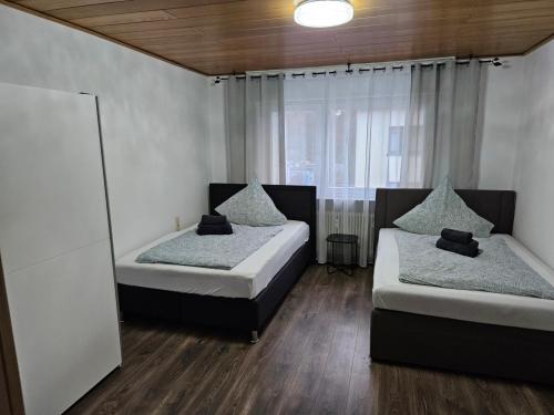 - une chambre avec 2 lits et une fenêtre dans l'établissement Ferienwohnung Saika, à Diefflen