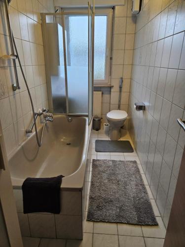 La salle de bains est pourvue d'une douche, d'une baignoire et de toilettes. dans l'établissement Ferienwohnung Saika, à Diefflen