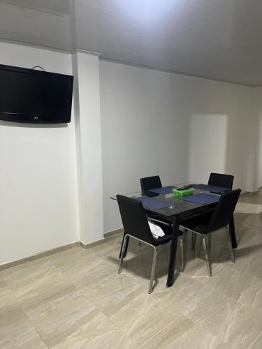 a black table and chairs in a room with a tv at Apartaestudio en la mesa in La Mesa