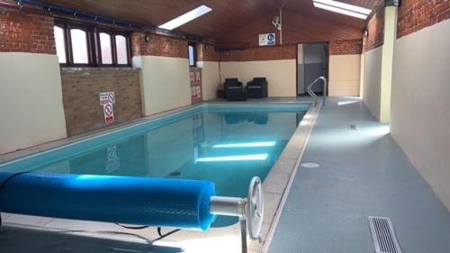 a large swimming pool in a building at The Stables in Tunstead