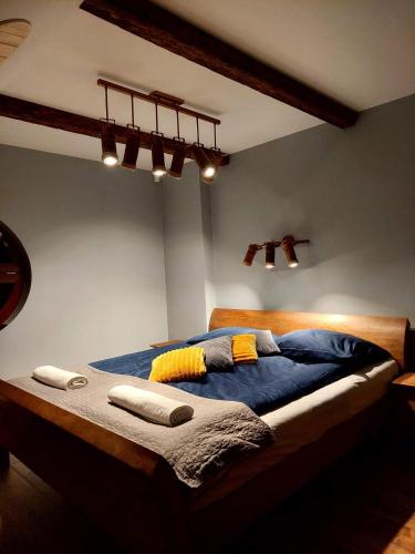 a bedroom with a bed with blue sheets and pillows at SASKI ZAKĄTEK, WAKACJE W BAJKOWYM DOMKU!!! MAZURY, SAUNA, JEZiORO, POMOST, in Sasek Mały