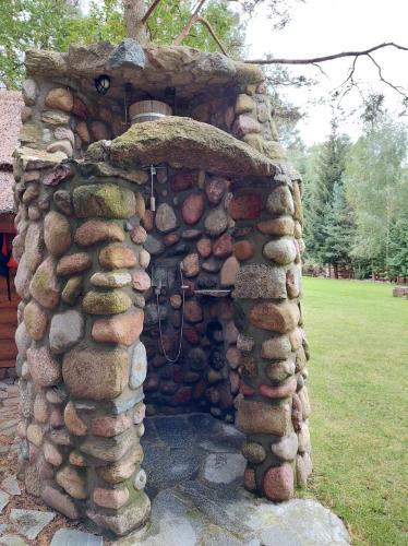 a stone building with a pile of rocks at SASKI ZAKĄTEK, WAKACJE W BAJKOWYM DOMKU!!! MAZURY, SAUNA, JEZiORO, POMOST, in Sasek Mały