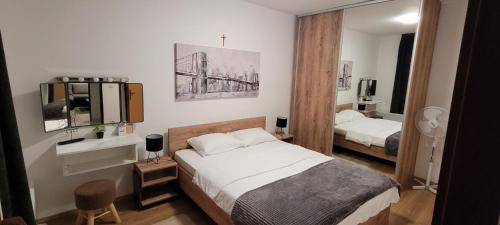 a bedroom with two beds and a tv and a mirror at Kod Dide - entry with pin 0-24h in Slavonski Brod