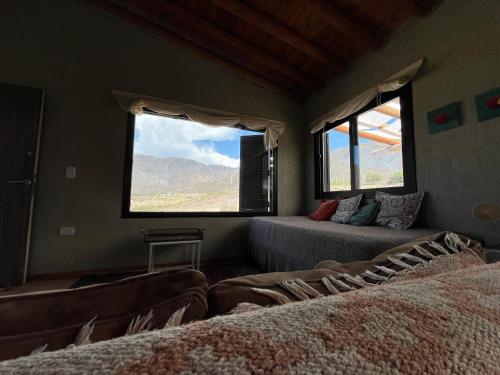 a room with two beds and a large window at Wabi sabi, casita de montaña con pileta in Mendoza