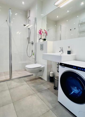a bathroom with a washing machine and a sink at Sopocka Bryza in Sopot